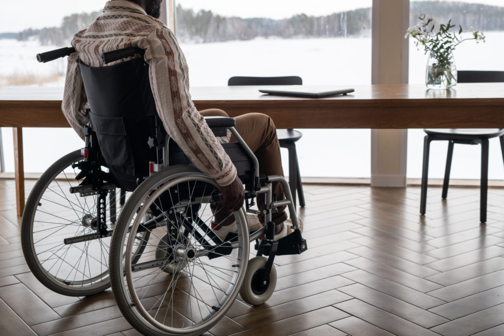 Young contemporary businessman with paralysis moving towards table