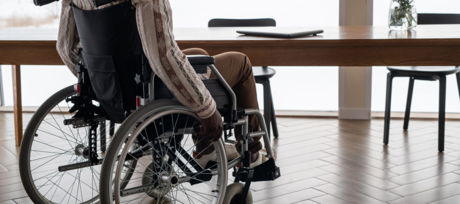 Young contemporary businessman with paralysis moving towards table